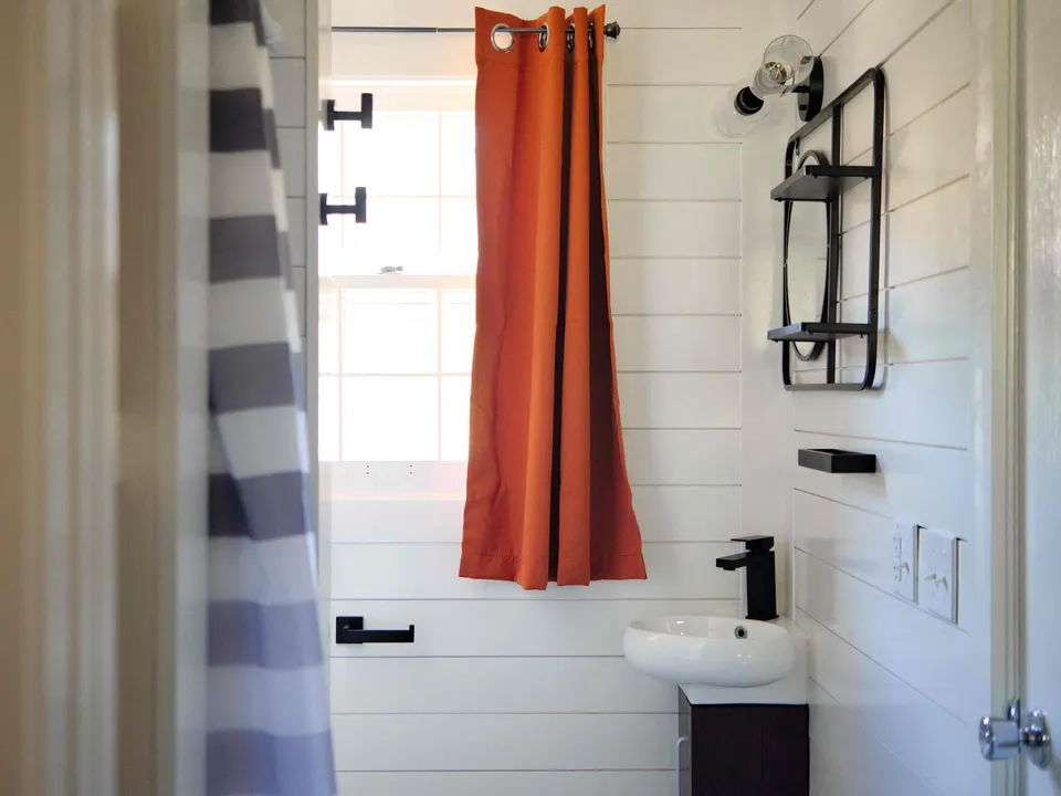 Shiplap bathroom with matte black fixtures, a compact vanity and a window