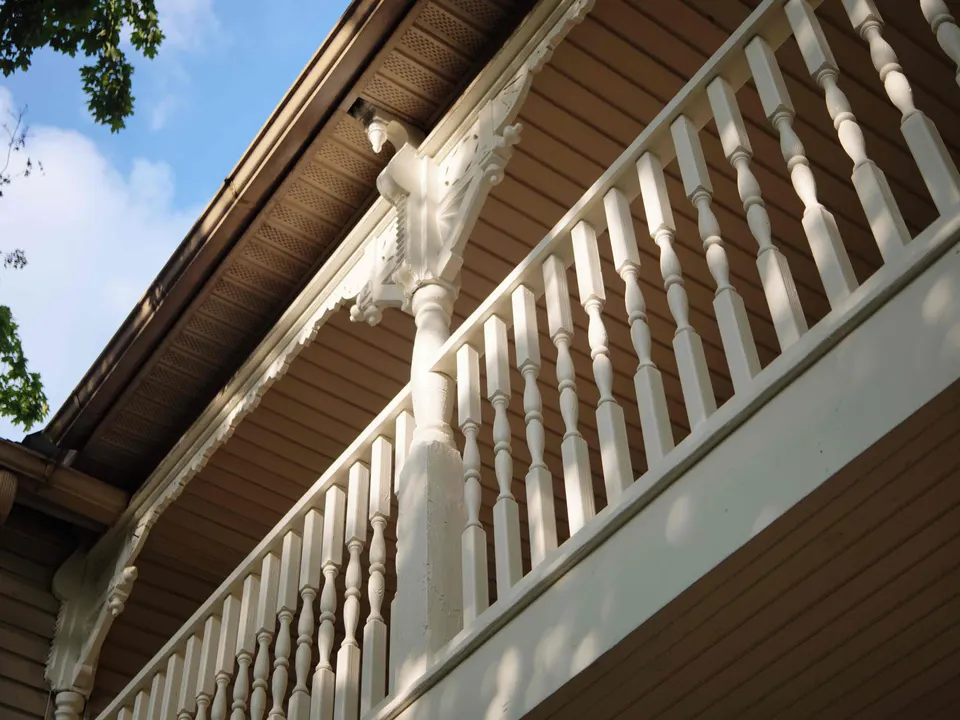 Turned spindle railing and carved bracket on a second-story balcony