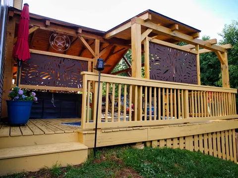Wood deck with a timber pavilion roof, pergola extension and decorative privacy screens