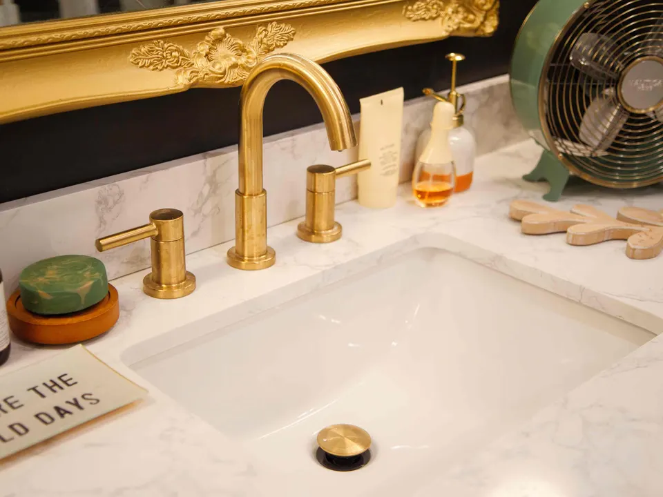 Brushed-brass faucet and undermount sink on a marble-look vanity top