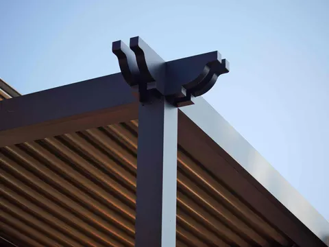 Black pergola post with decorative brackets and aluminum louvers