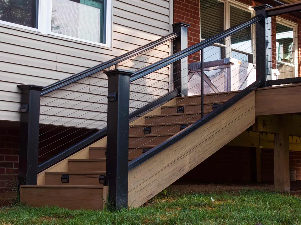 Composite deck stairs with black posts, post lights and stainless cable railing